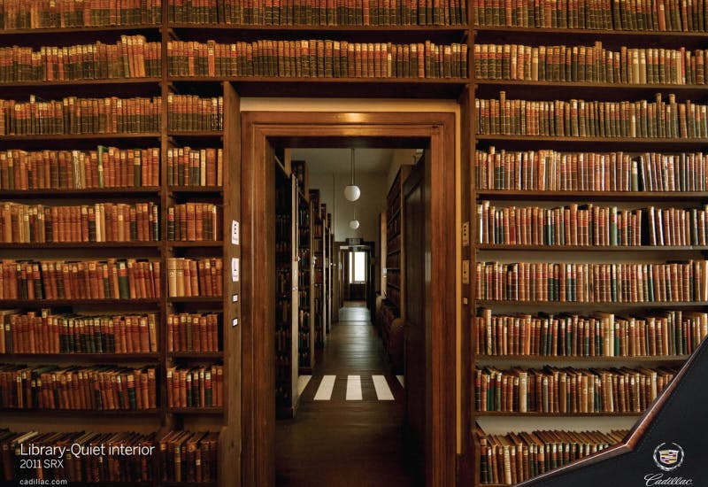 Cadillac SRX print ad comparing the car's quiet interior to a grand library filled with antique books