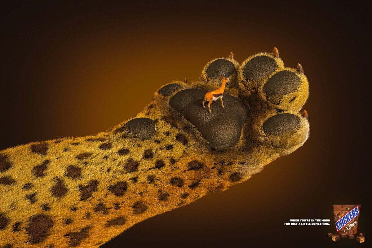 Snickers Bites ad showing a tiny gazelle standing on a giant cheetah paw with the tagline When you're in the mood for just a little something